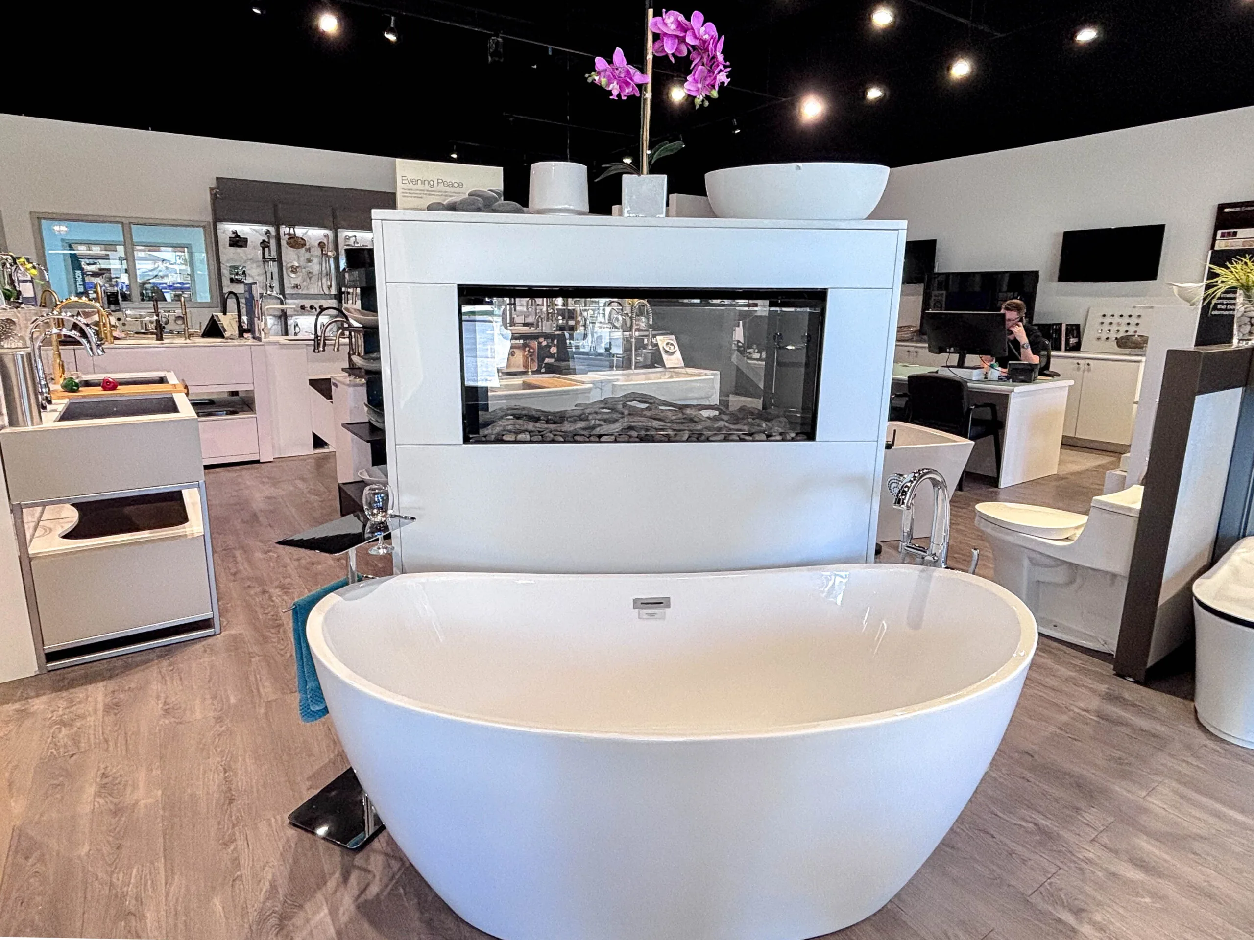 Freestanding bathtub in front of a fireplace display in the showroom